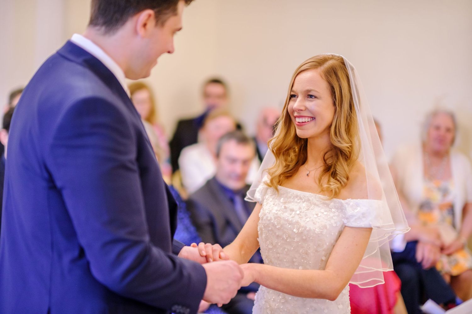 Wedding celebration in a bright indoor venue with guests dancing and celebrating.
