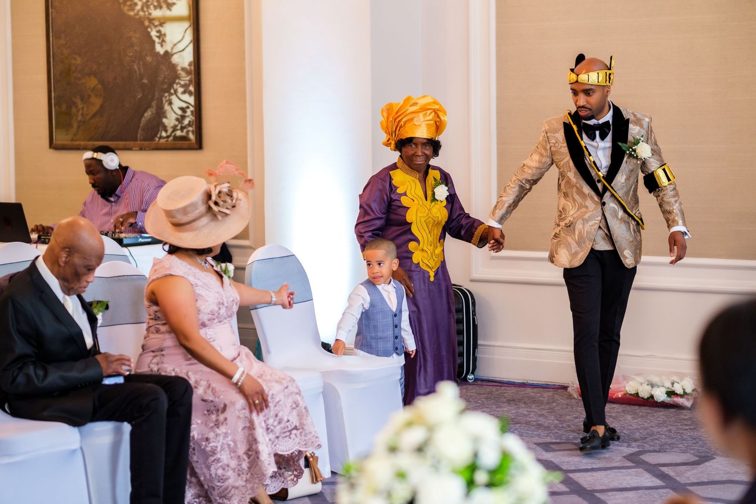 Wedding reception guests mingling and socializing in an elegant indoor venue with white decor.