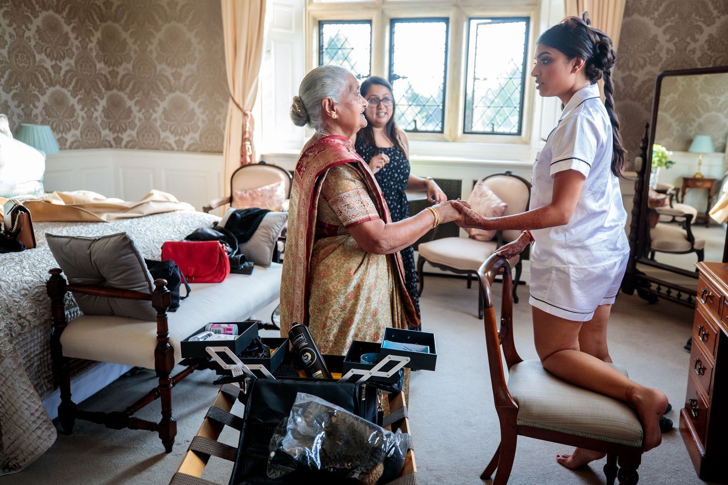 Elderly residents in a care facility engage in various activities with caregivers in a bright indoor setting.