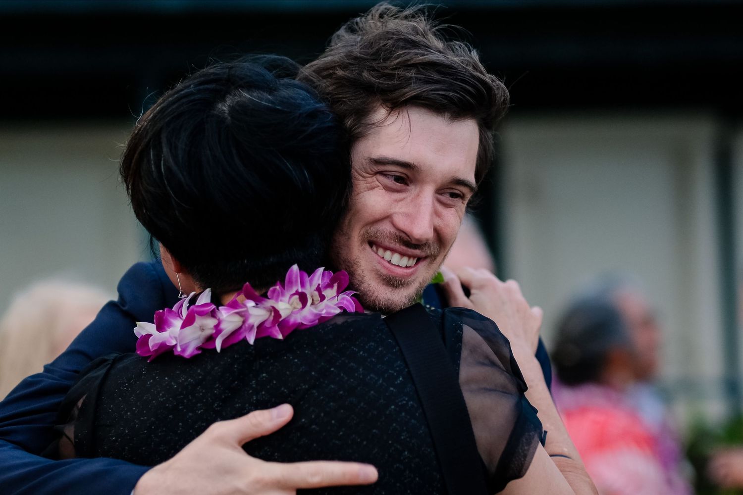 Wedding guests sharing emotional embraces during an outdoor celebration.