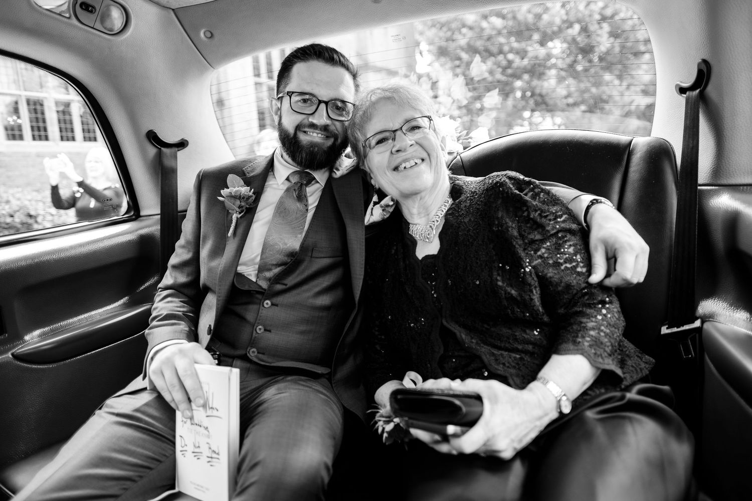 Black and white candid wedding photos showing joyful moments shared in a car.