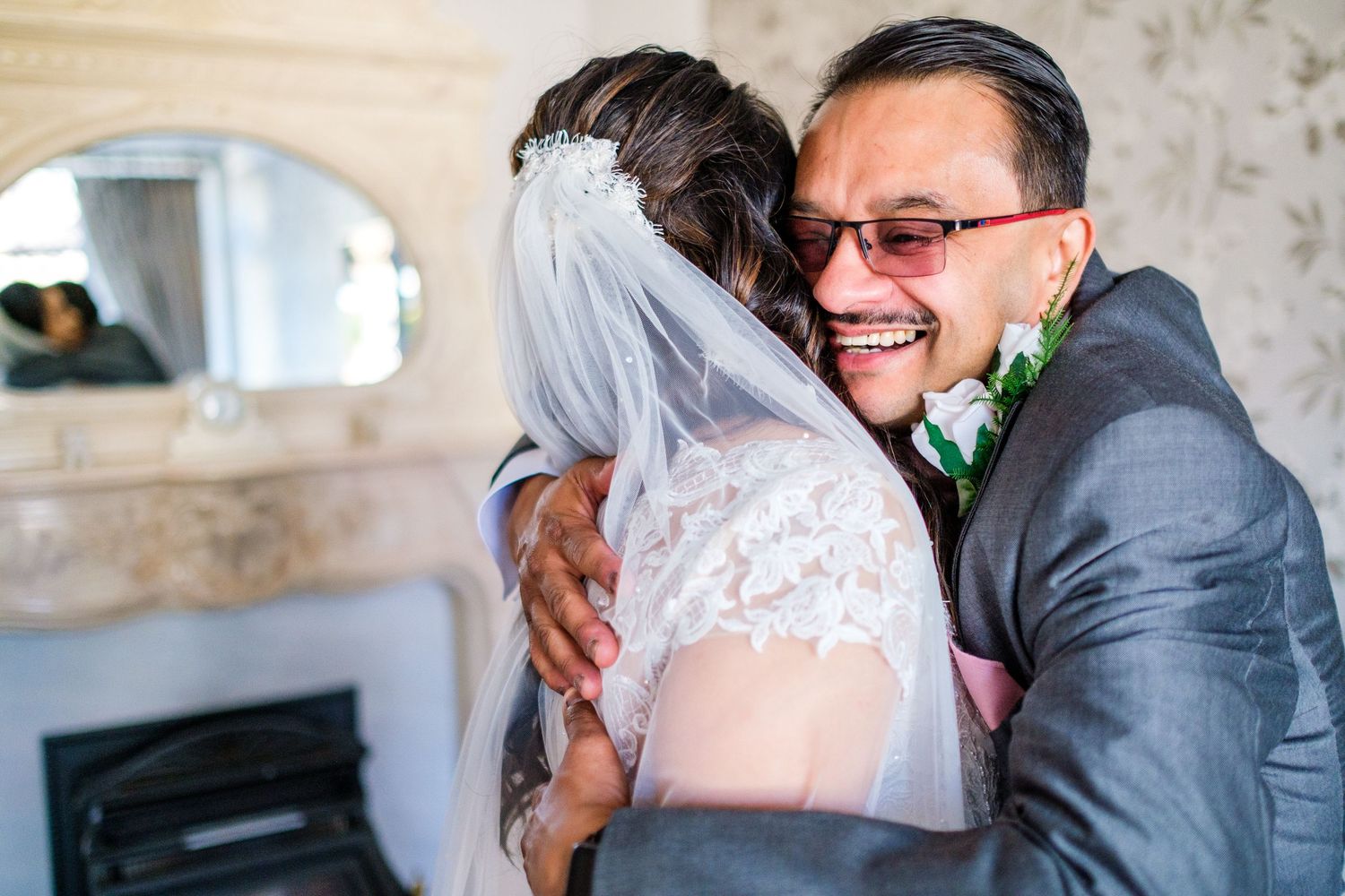 Joyful candid reactions during an indoor wedding celebration with guests and a couple in formal attire.