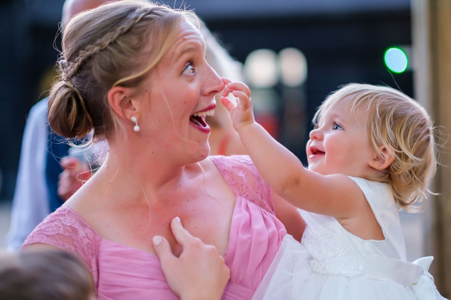 Wedding party members in pink dresses sharing joyful moments during the celebration.