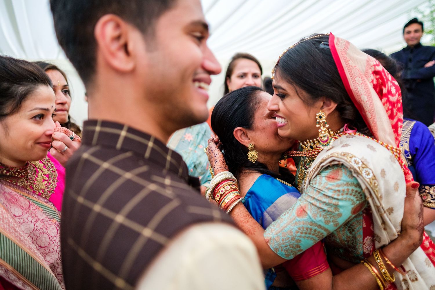 Candid moments of celebration and laughter during a traditional Indian wedding gathering.