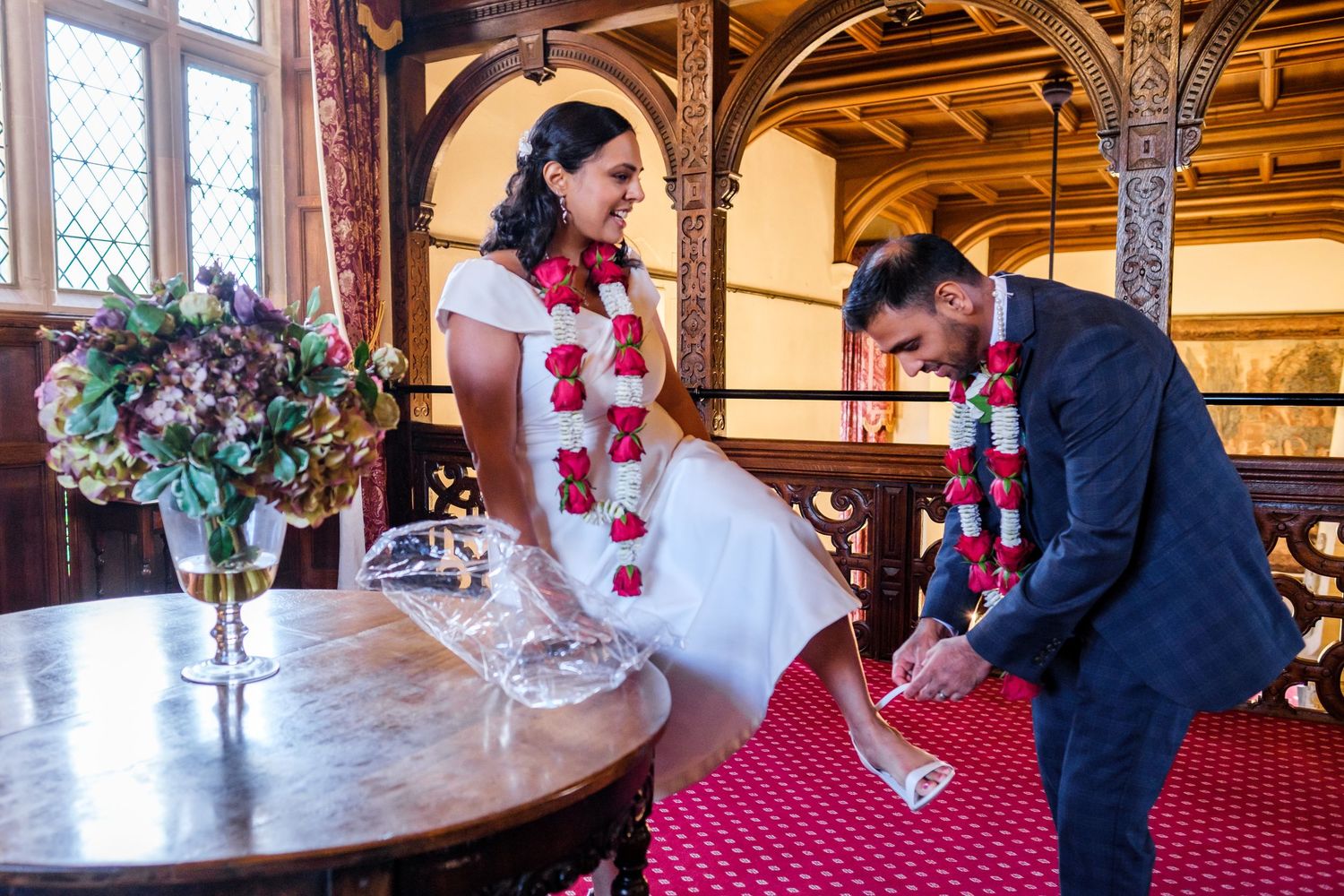 Wedding reception details with elegant table settings, floral arrangements and vintage decor in a historic venue.