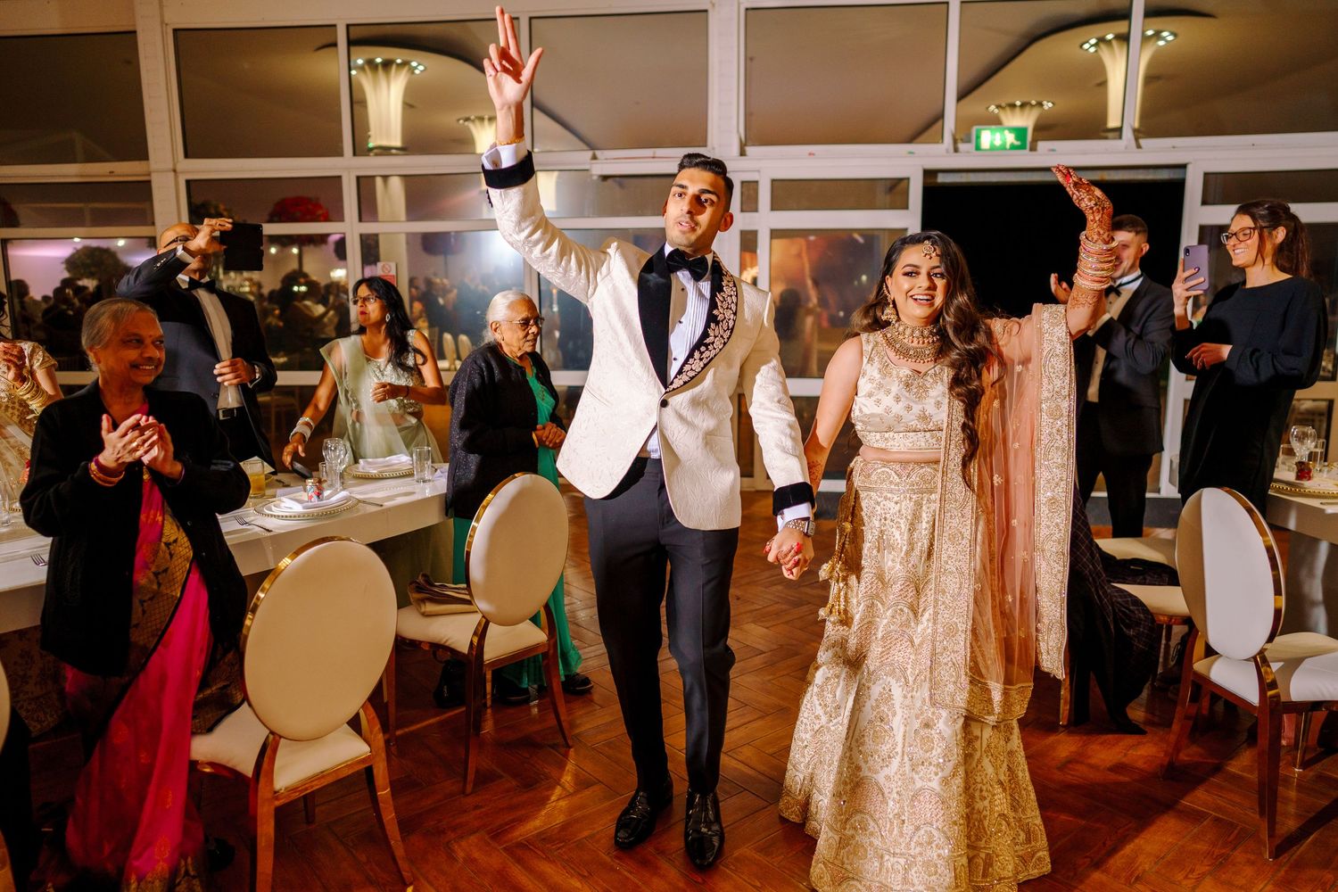 Wedding reception venue with guests dancing and celebrating in an elegant ballroom.