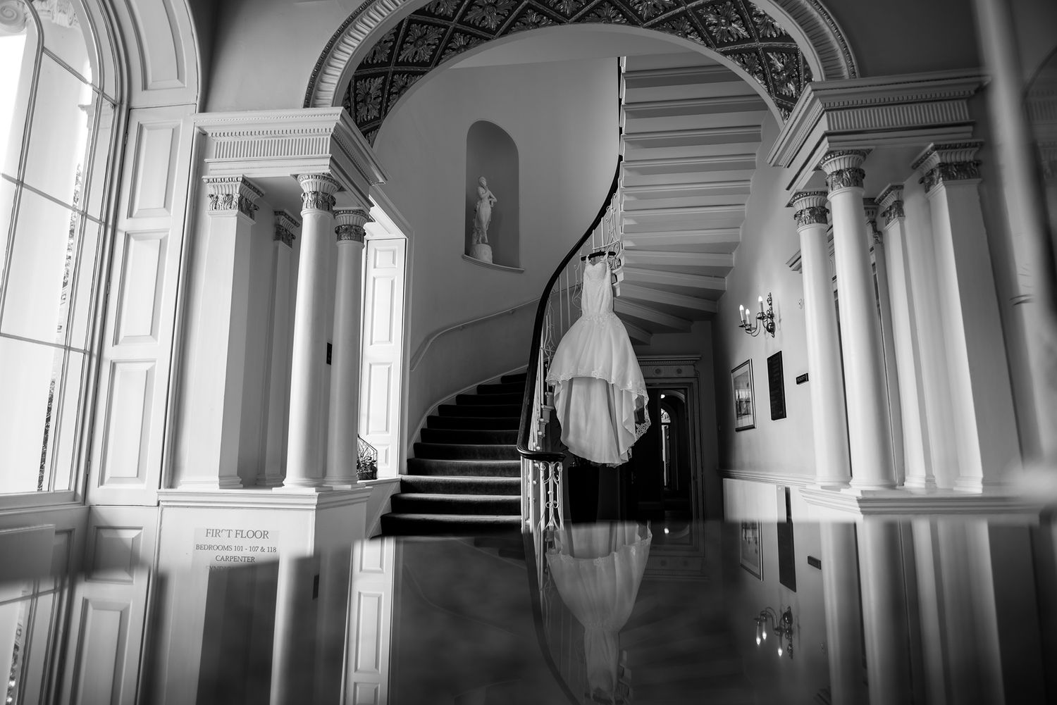 Architectural details of a grand hallway with classical columns and arched windows.