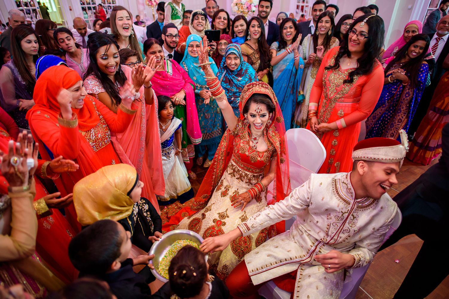 Festive wedding reception dance party with guests in traditional Indian attire.