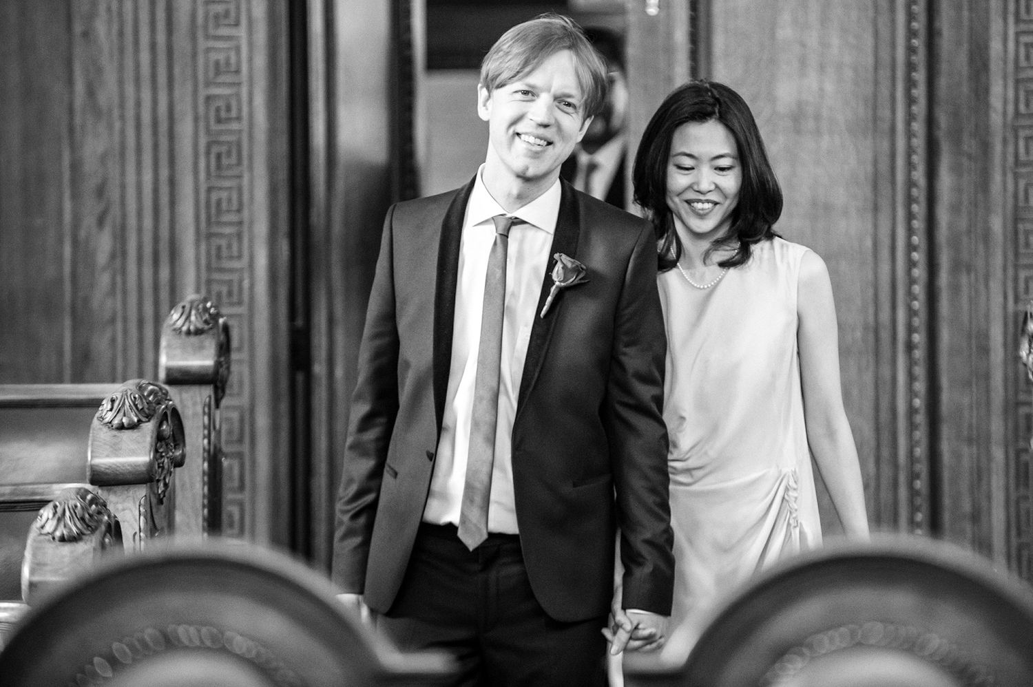 Black and white candid moments captured in front of an elegant architectural entrance.