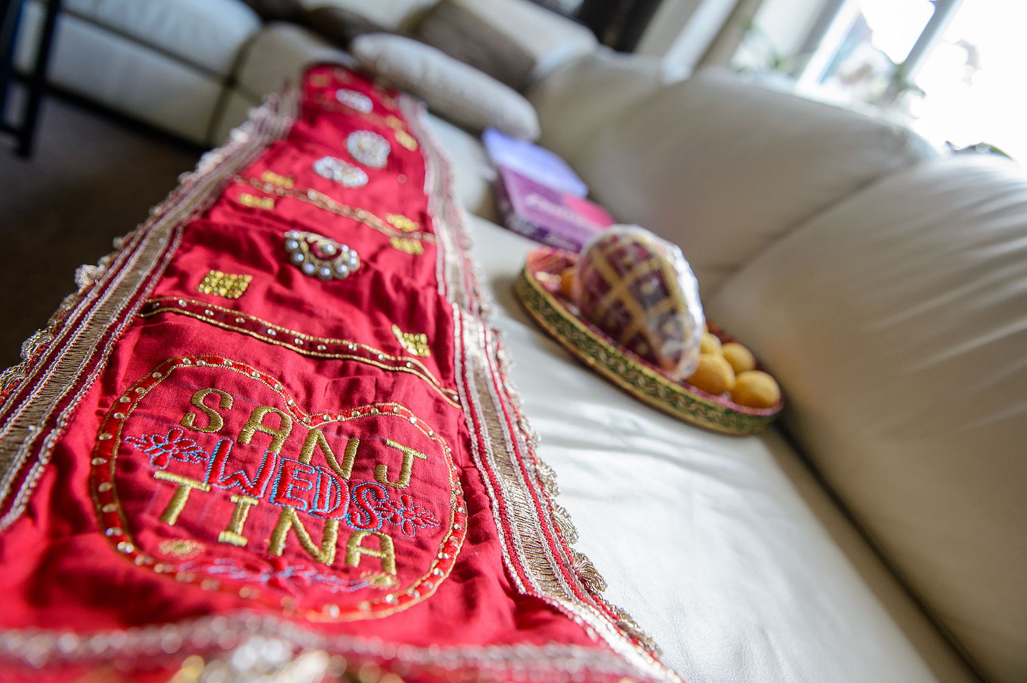 Decorative red and gold embroidered fabric with intricate beadwork details.