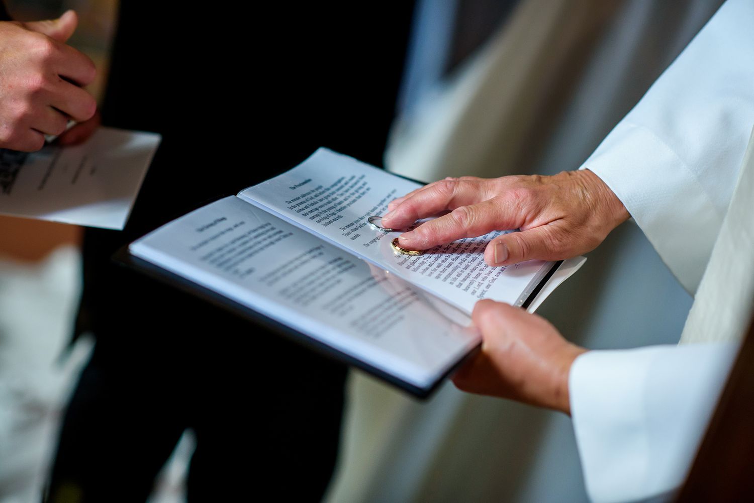 Wedding ceremony participants reviewing documents together during the service.