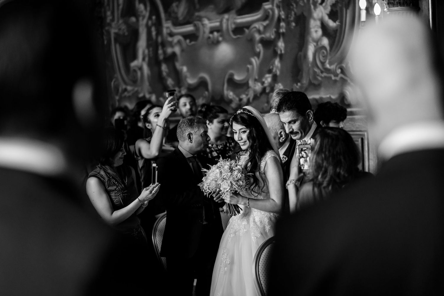 Black and white photo of wedding ceremony moments in an elegant indoor venue.