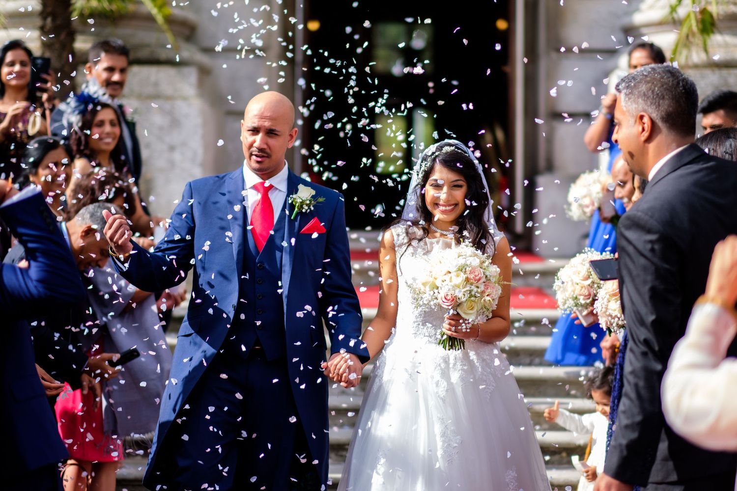 Wedding party showered with confetti during a joyous outdoor celebration.