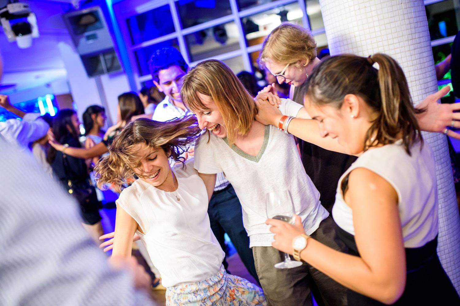 Celebration event with party guests dancing under blue atmospheric lighting.