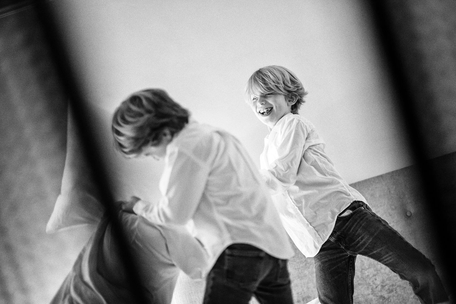 Black and white silhouettes of figures dancing in ethereal motion against a light background.
