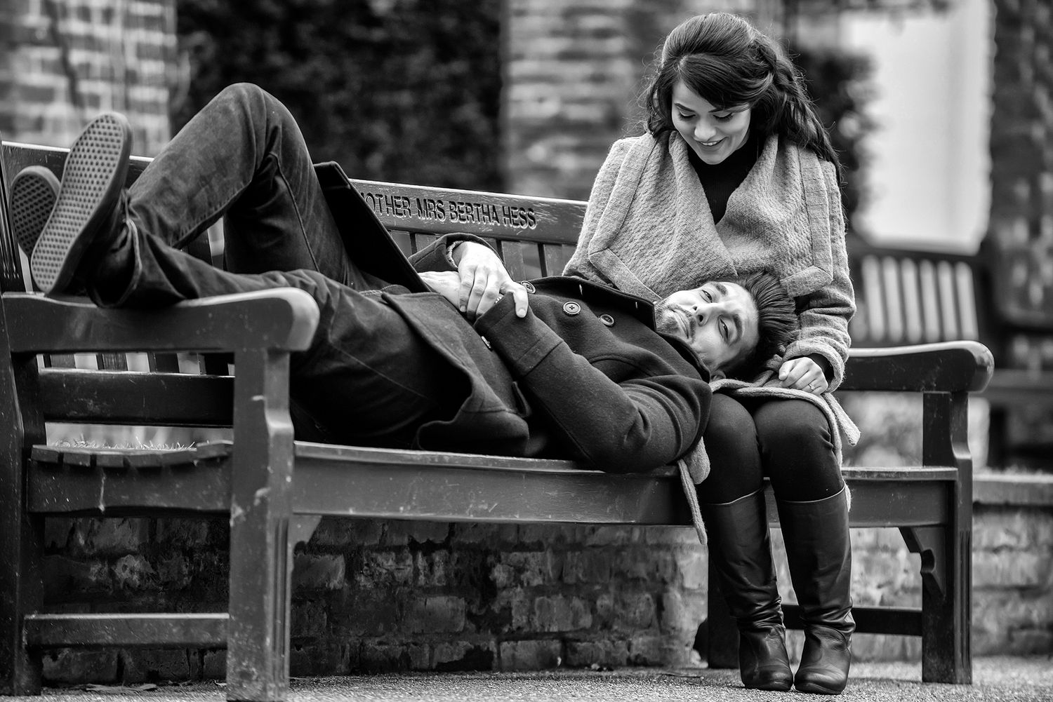 Artistic black and white portrait session on wooden park bench.