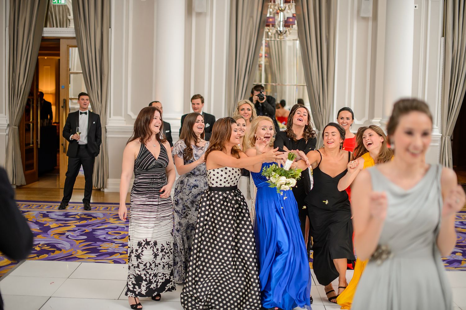 Wedding party guests dancing and celebrating in a luxurious indoor venue with elegant decor.