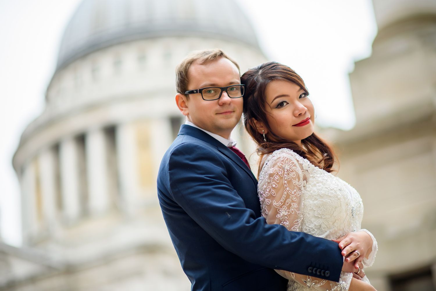 A tender moment between newlyweds with London's St Paul's Cathedral dome in the background.