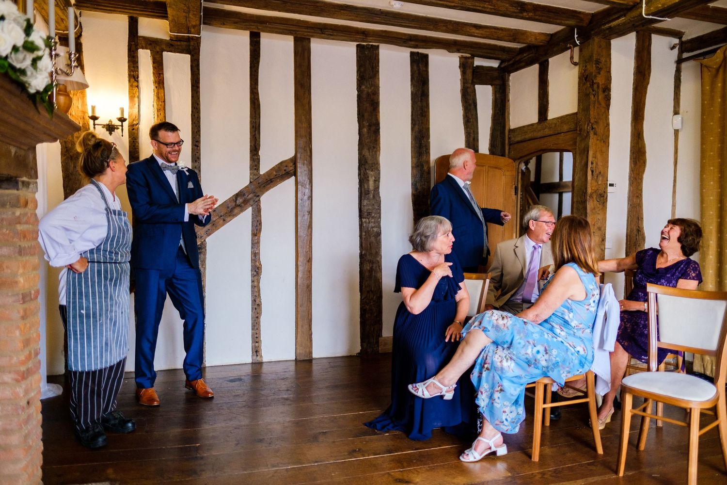 Interior view of a rustic timber-framed venue with guests seated for a wedding ceremony.