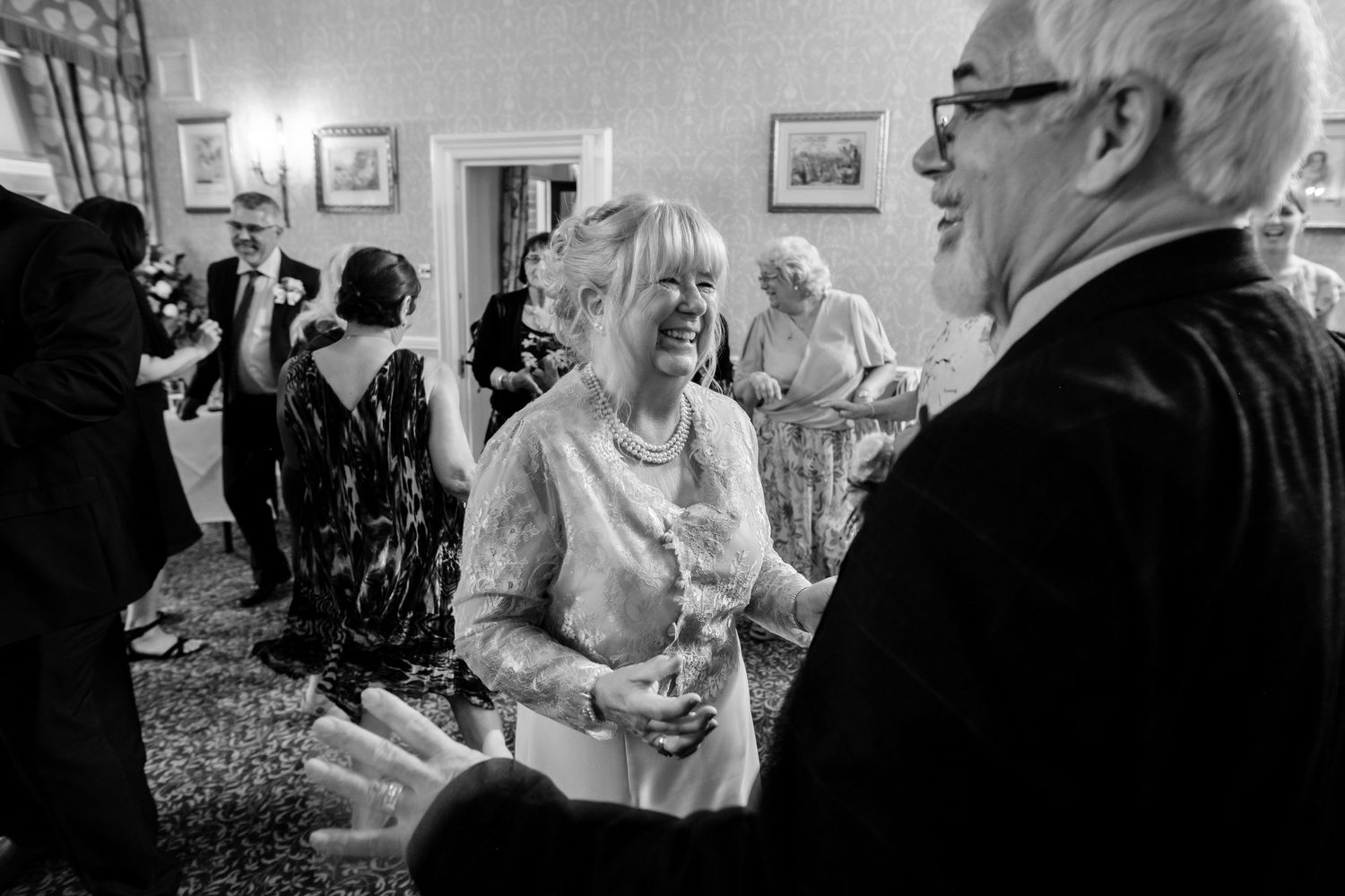 Black and white candid shots capture joyful moments during a wedding celebration.