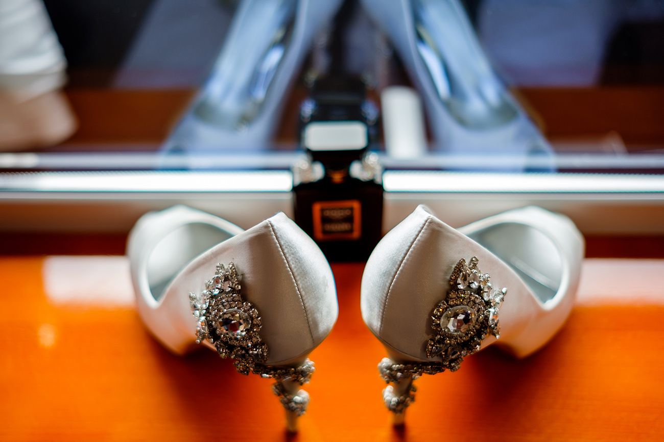 Close-up view of decorative white ceramic teacups arranged in a row on orange surface.