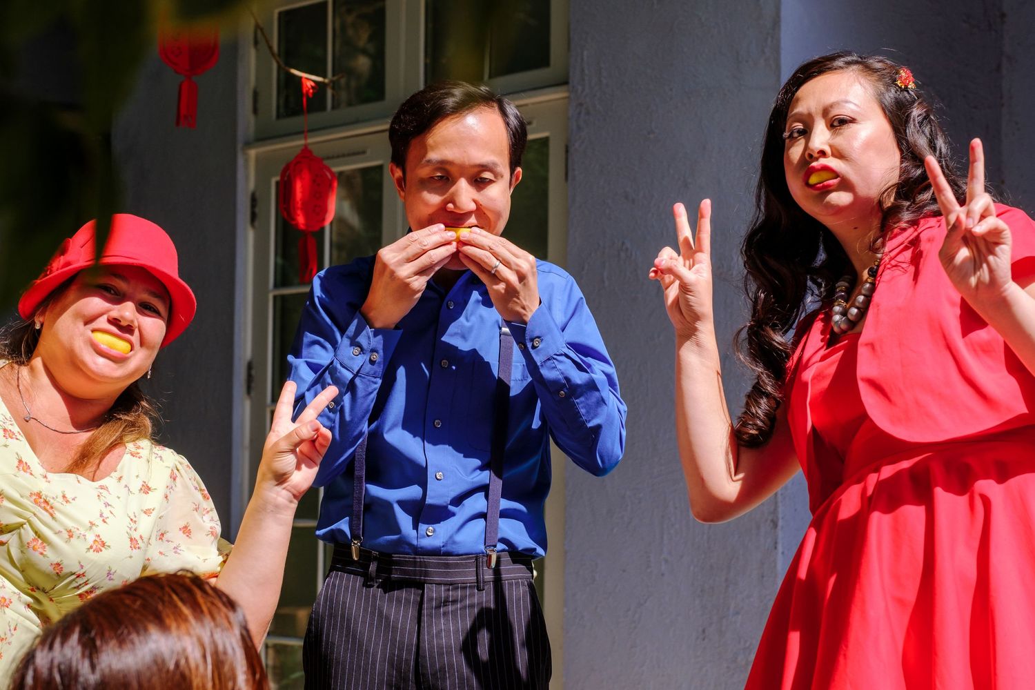 A group of people in blue and red outfits pose playfully making peace signs and funny faces in a casual photo series.