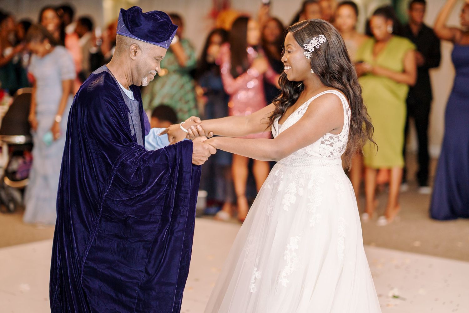 Wedding guests dancing and celebrating at an indoor reception venue.