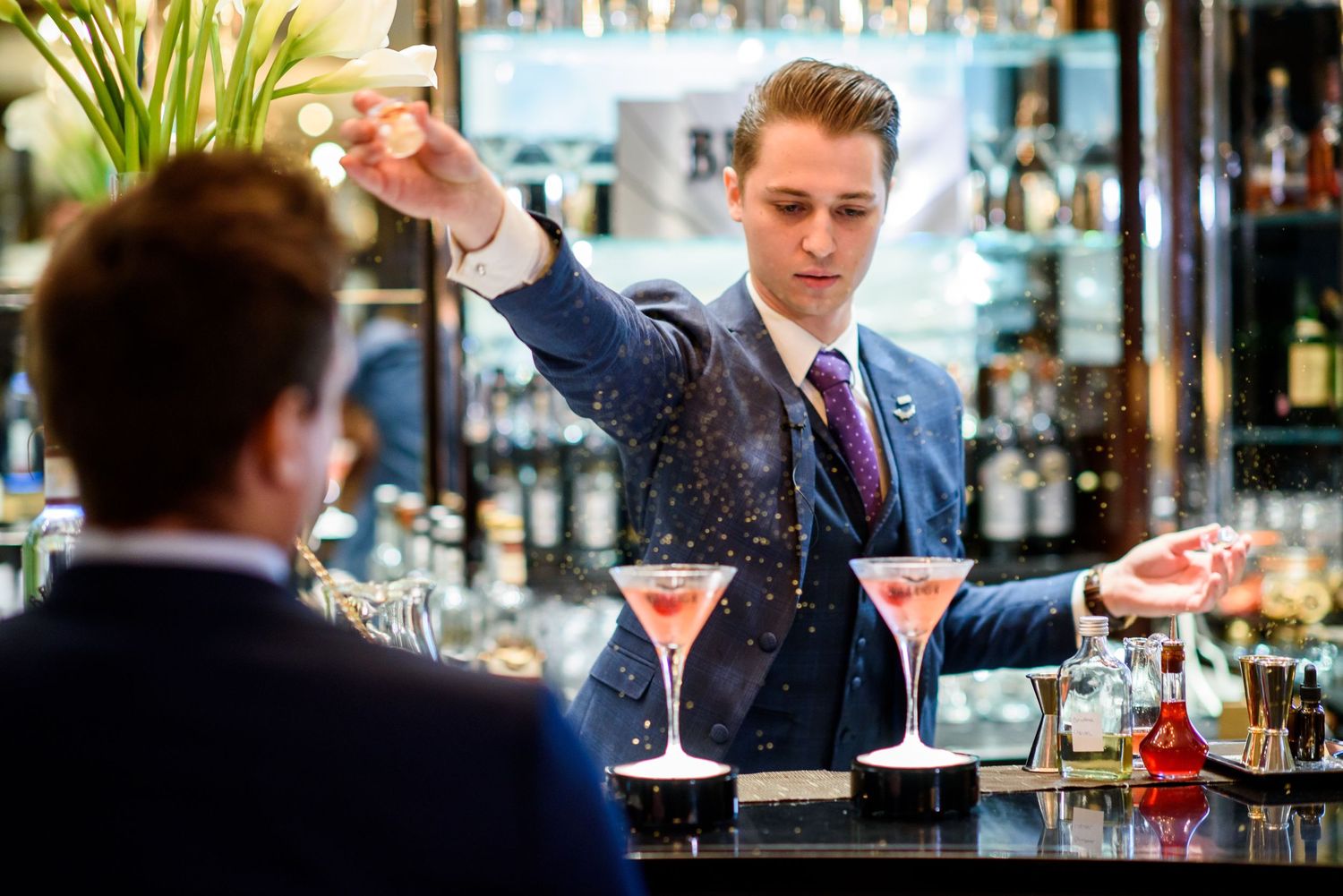 Elegant bar setting with cocktail glasses and professional service during an evening event.