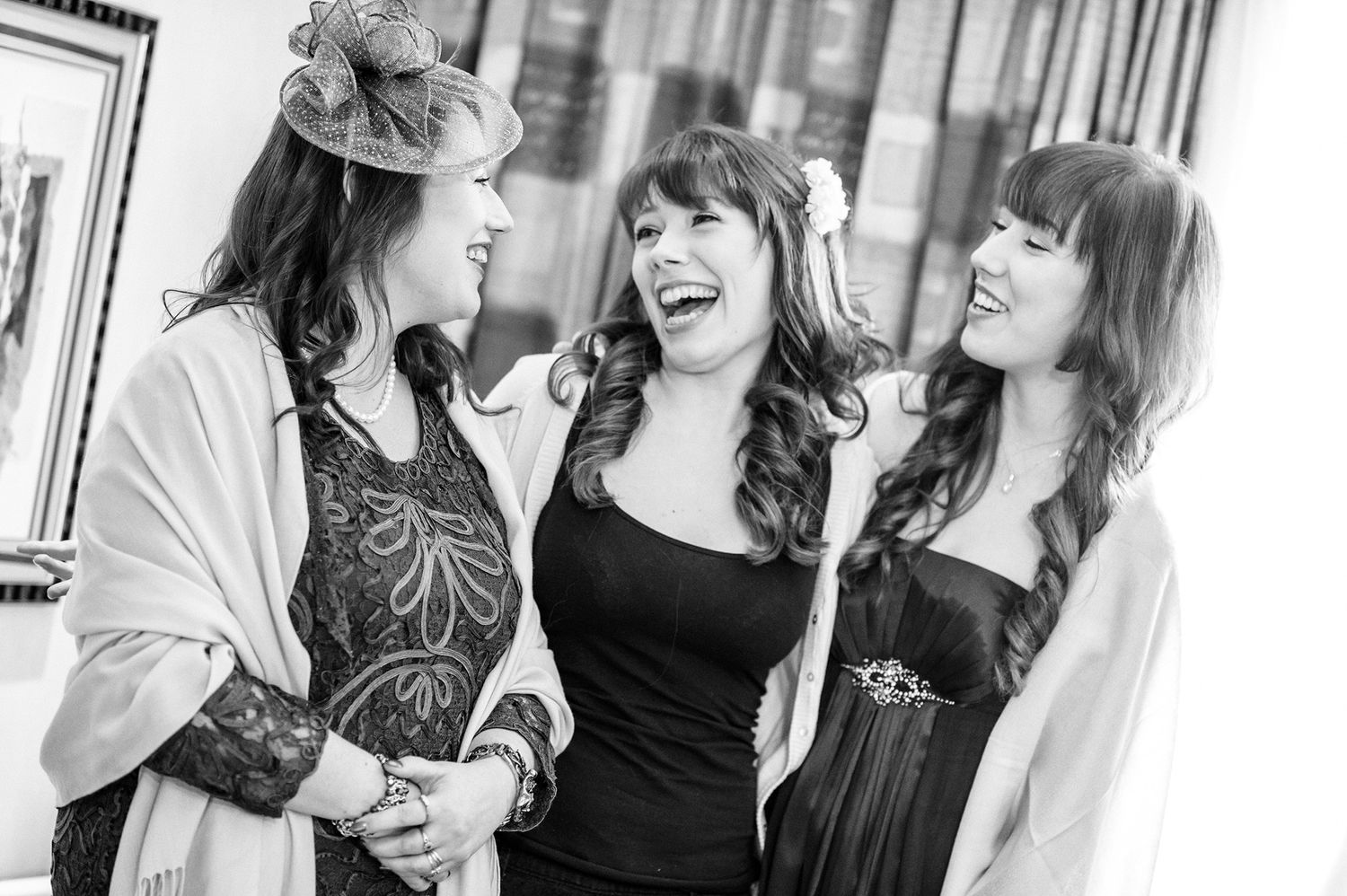 Joyful group of women in formal wear sharing laughter at an elegant event.