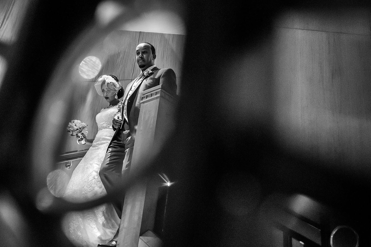 Artistic black and white wedding photography captures candid moments through reflections.
