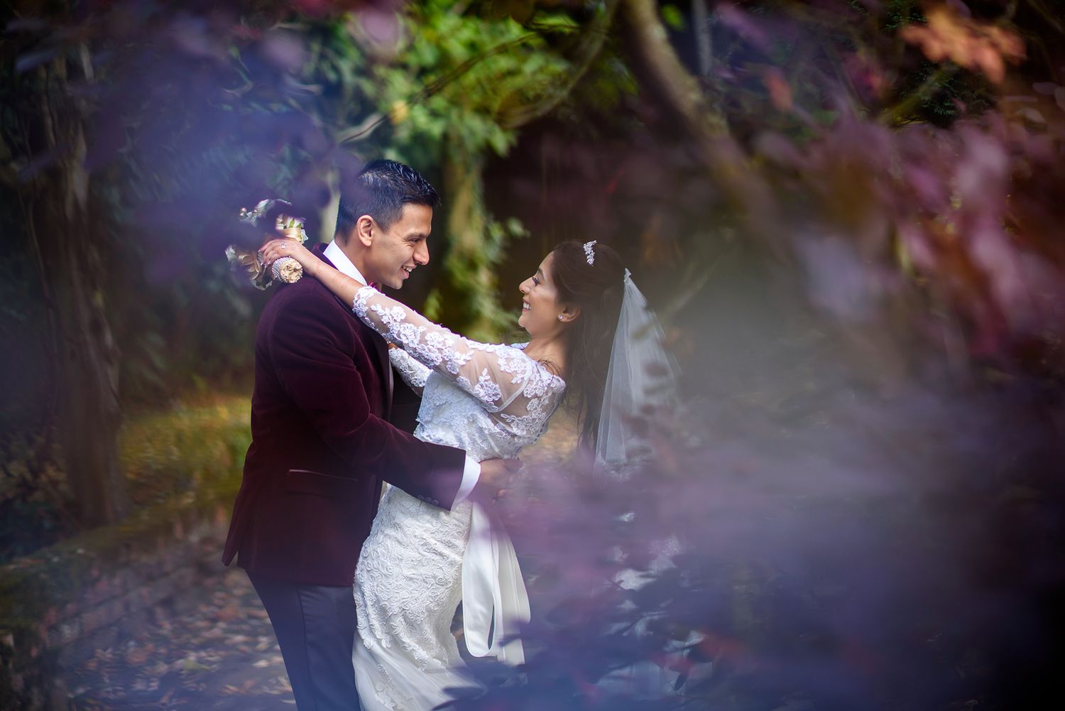 Artistic wedding shot with natural greenery and bokeh effect.