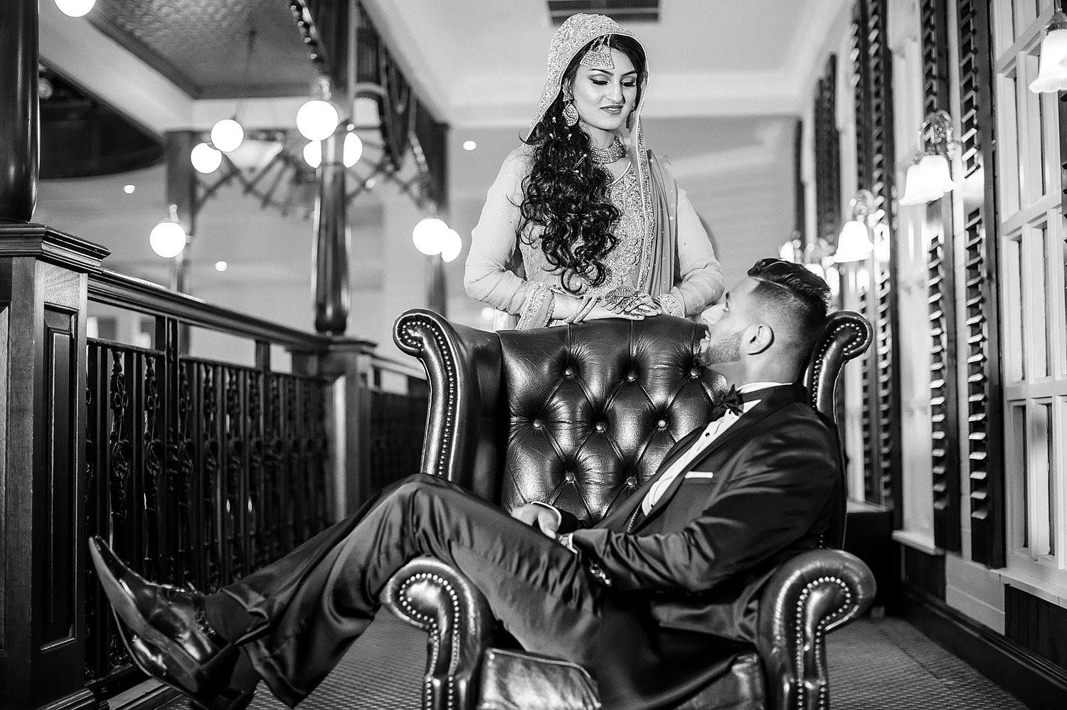 Black and white photo of couple in luxurious leather chair setting.