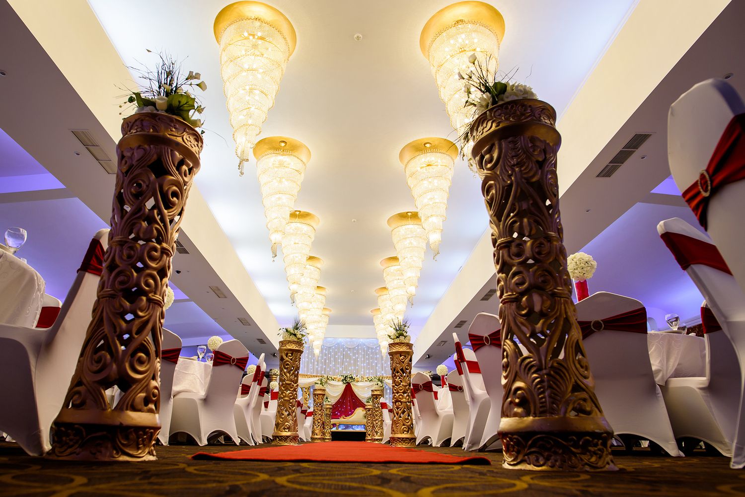 Elegant venue ceiling decorated with ornate lighting fixtures and architectural details.