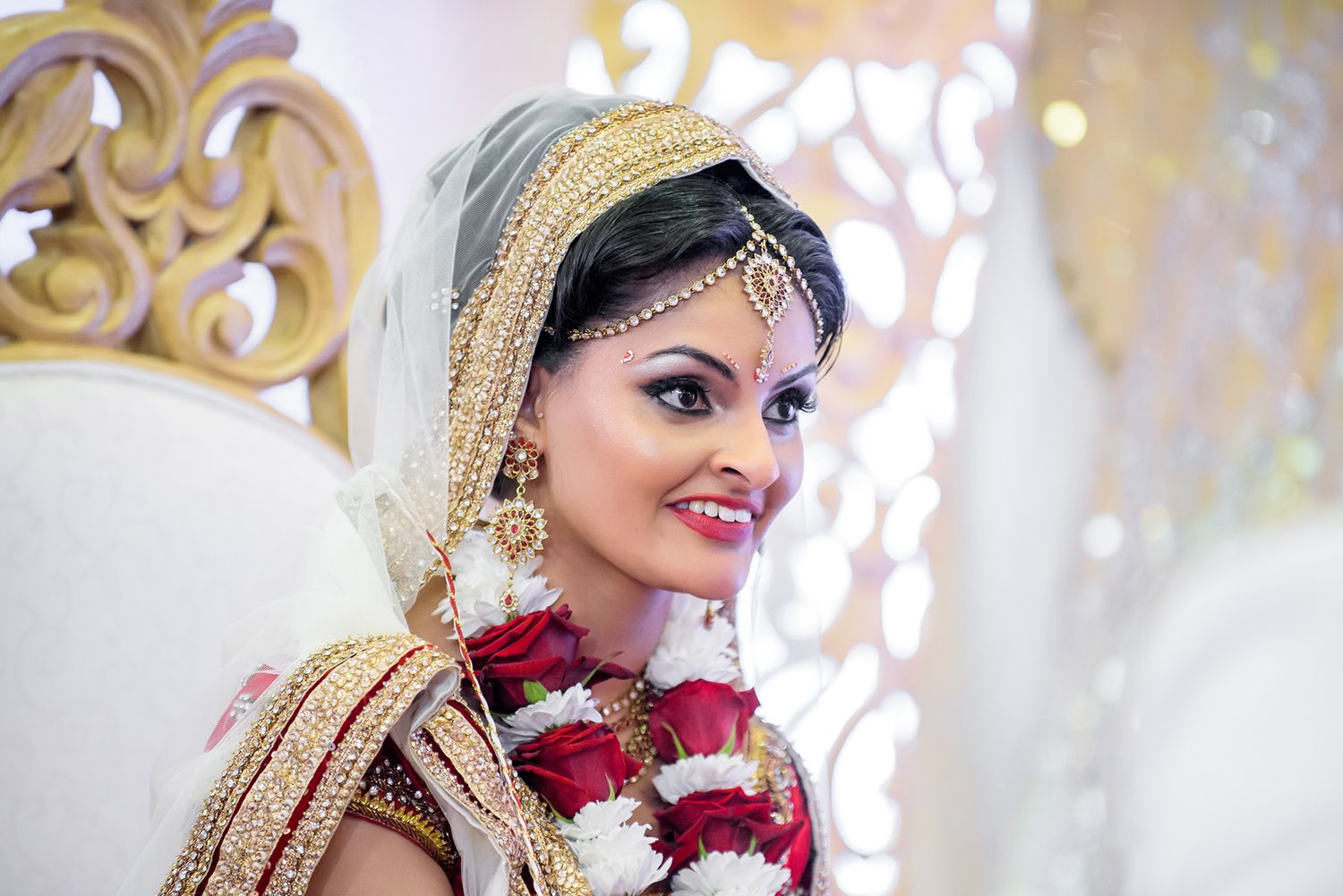 Traditional Indian wedding ceremony with decorative gold elements and bright lighting.