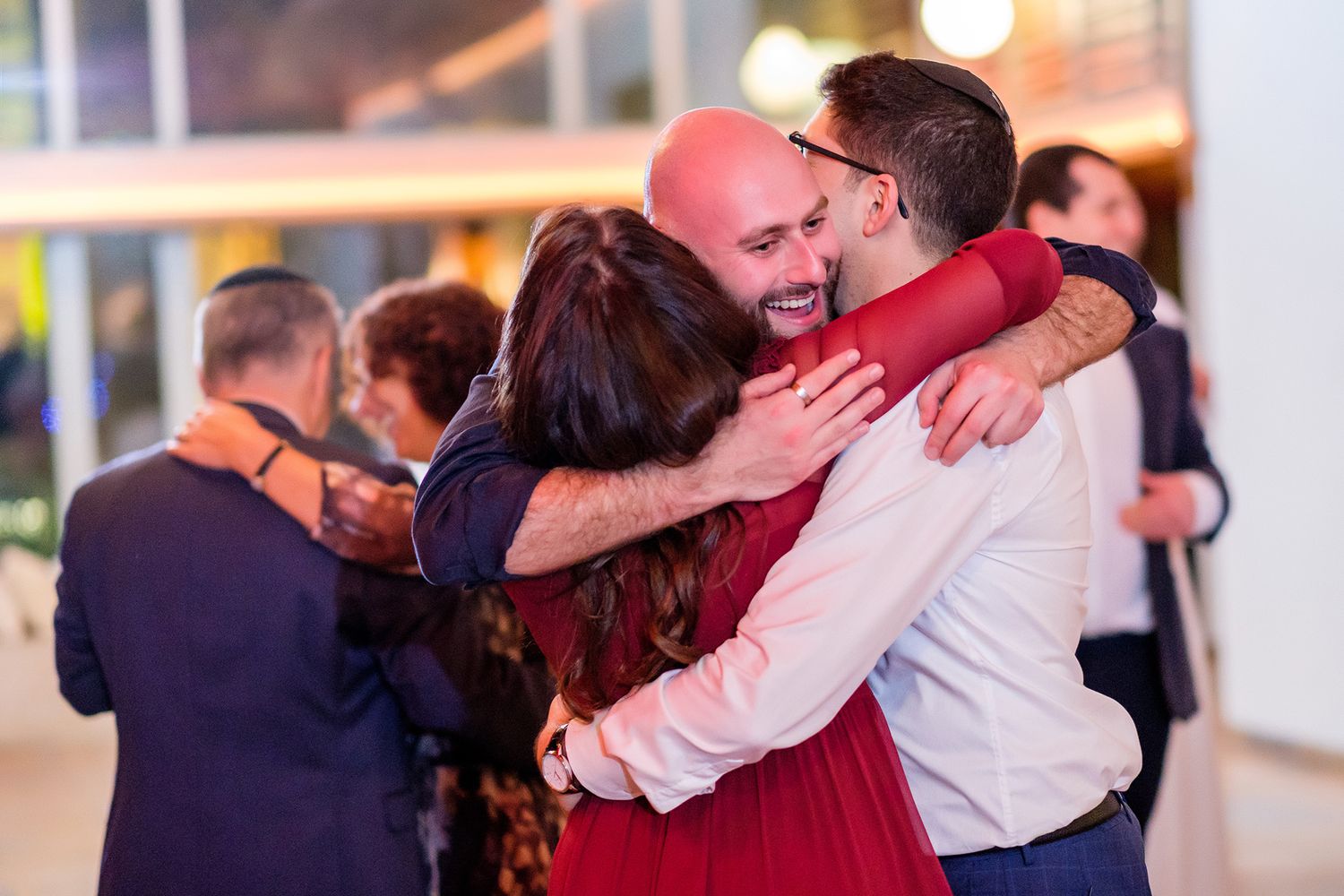 Dancers embracing during romantic slow dances at an indoor venue with ambient lighting.