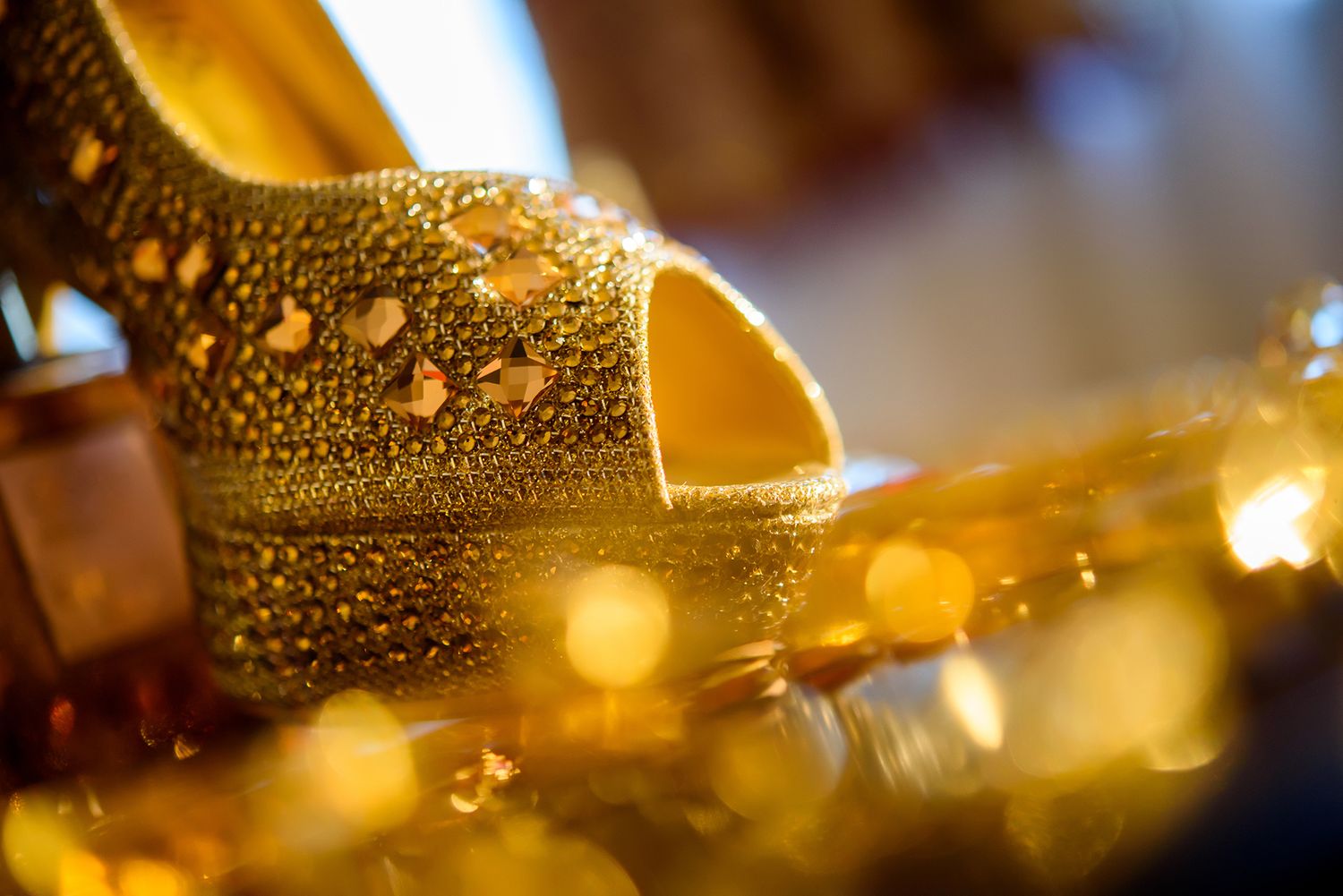 Droplets of water on glass create a golden bokeh pattern in macro photography.