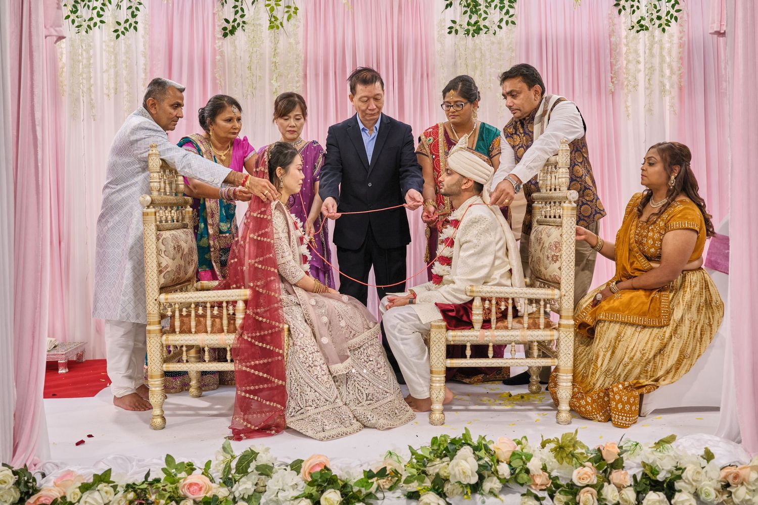 Wedding celebration setup with pink drapes and floral decorations against an elegant backdrop.