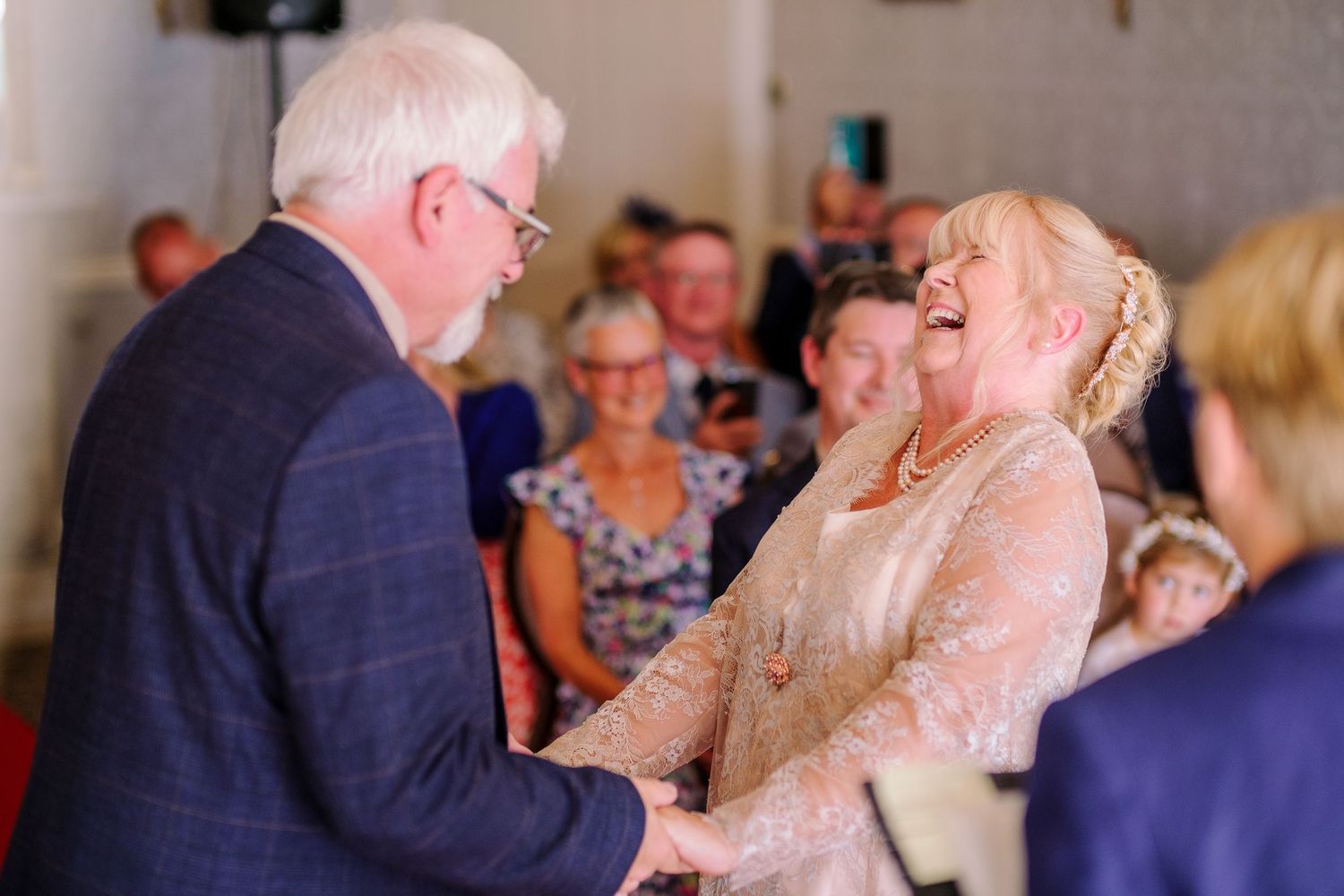 Elderly couple sharing a joyful moment together at an indoor celebration.