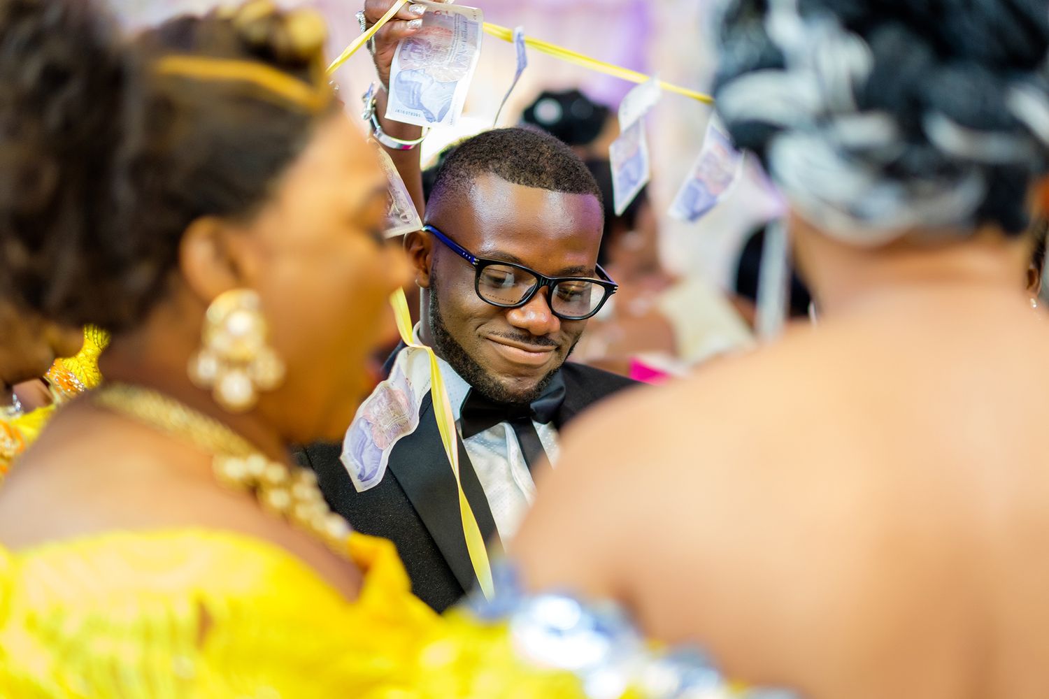 Close-up of guest dancing among celebratory crowd at wedding reception.