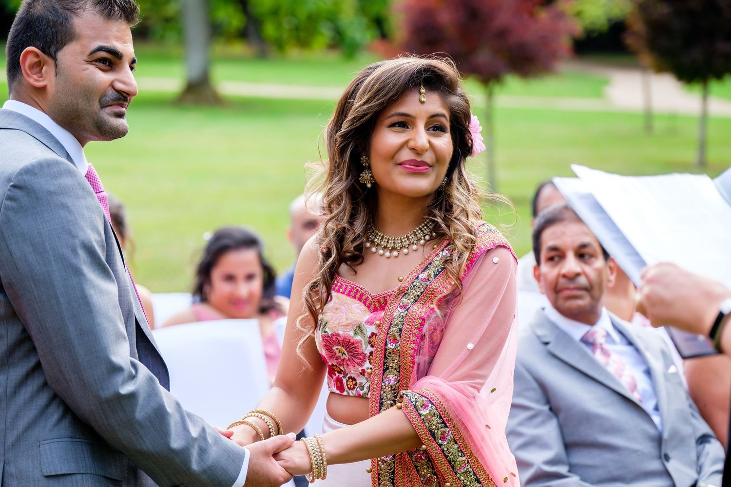Outdoor wedding ceremony with colorful floral arrangements and traditional attire.