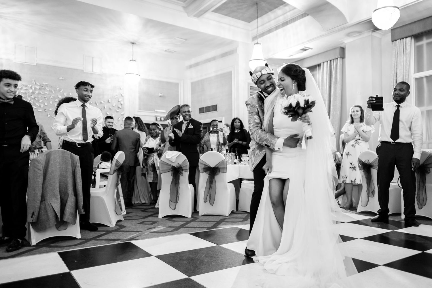 Black and white photo series of wedding guests dancing and celebrating at an elegant indoor reception.