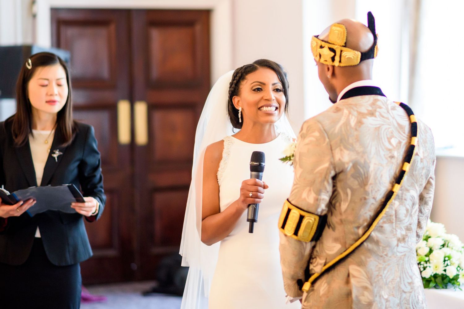 Wedding ceremony with couple exchanging vows in front of wooden doors.