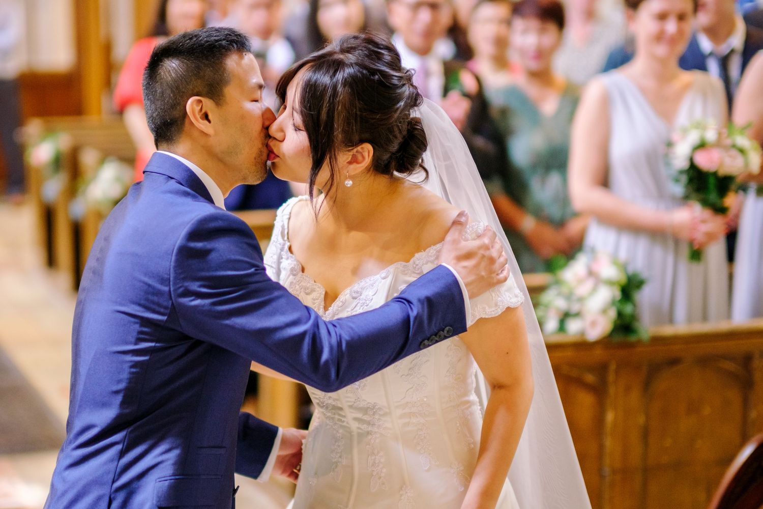 A couple shares a romantic moment during their wedding ceremony in a beautifully decorated church setting.