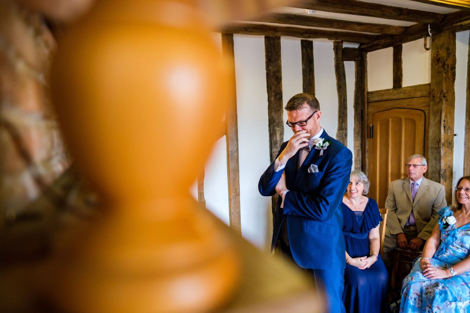 Wedding guests watching emotional first look moment in rustic venue.