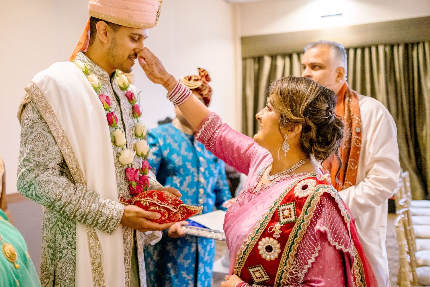 Wedding party members in traditional Indian formal wear pose together during festivities.