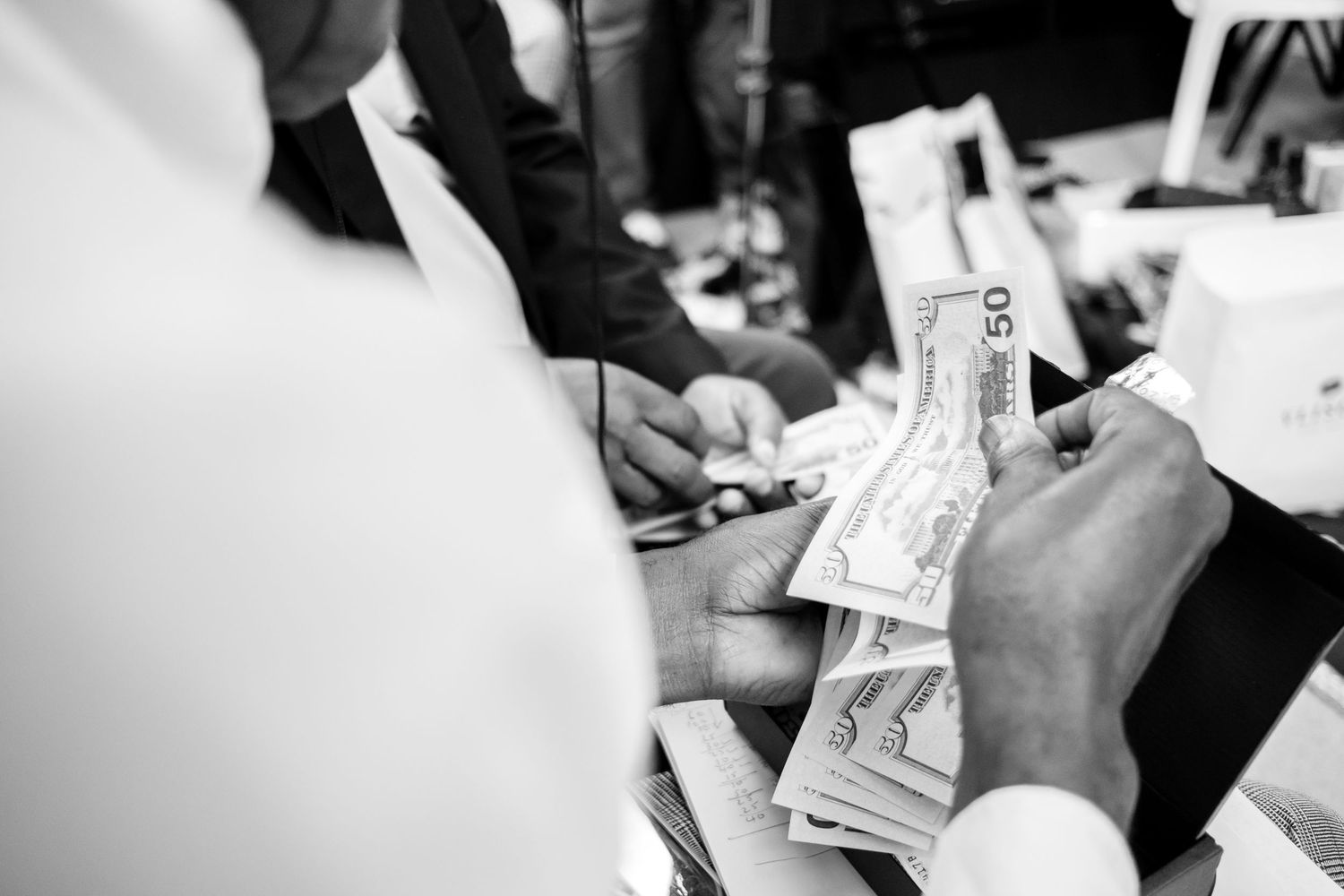 Close-up of hands exchanging or handling paper documents.