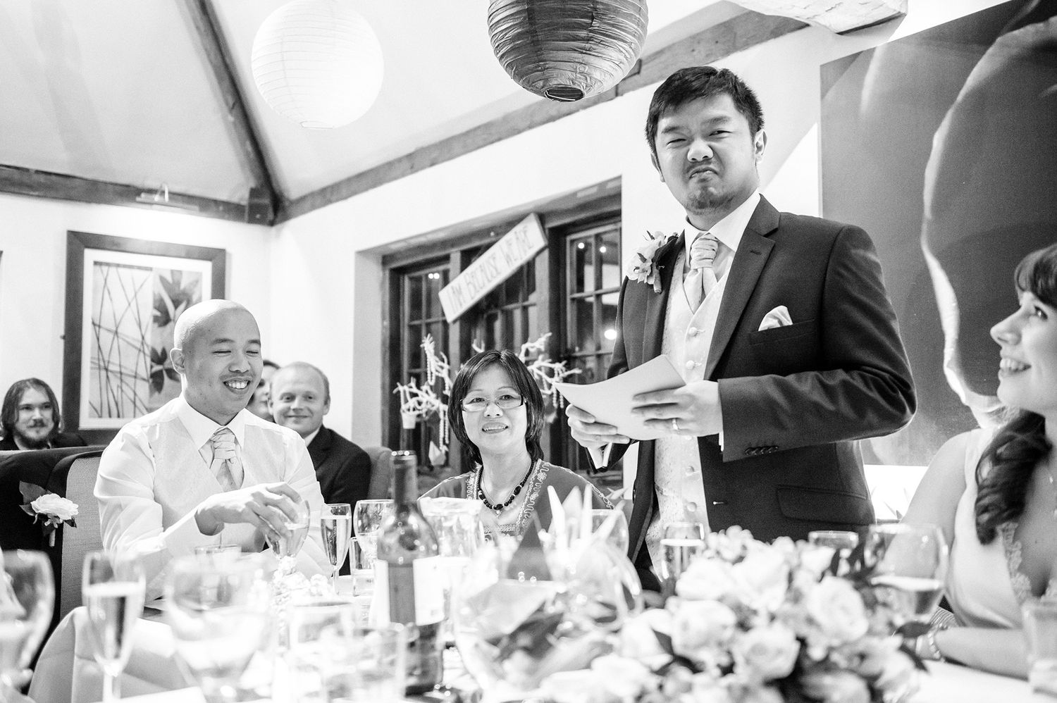Candid black and white shots of wedding guests enjoying dinner celebration.