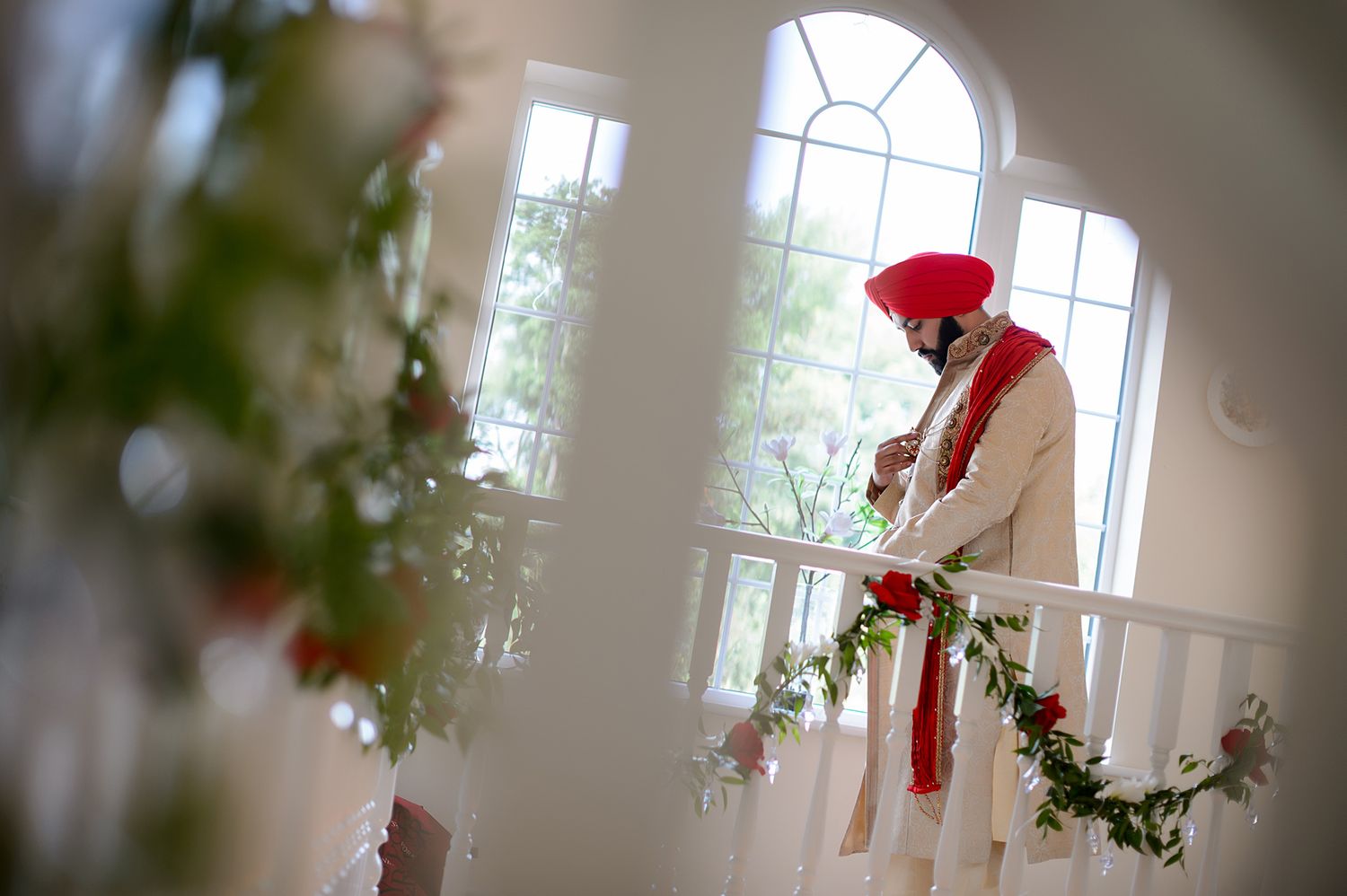 Interior of an elegant white room with large windows and holiday decorations.