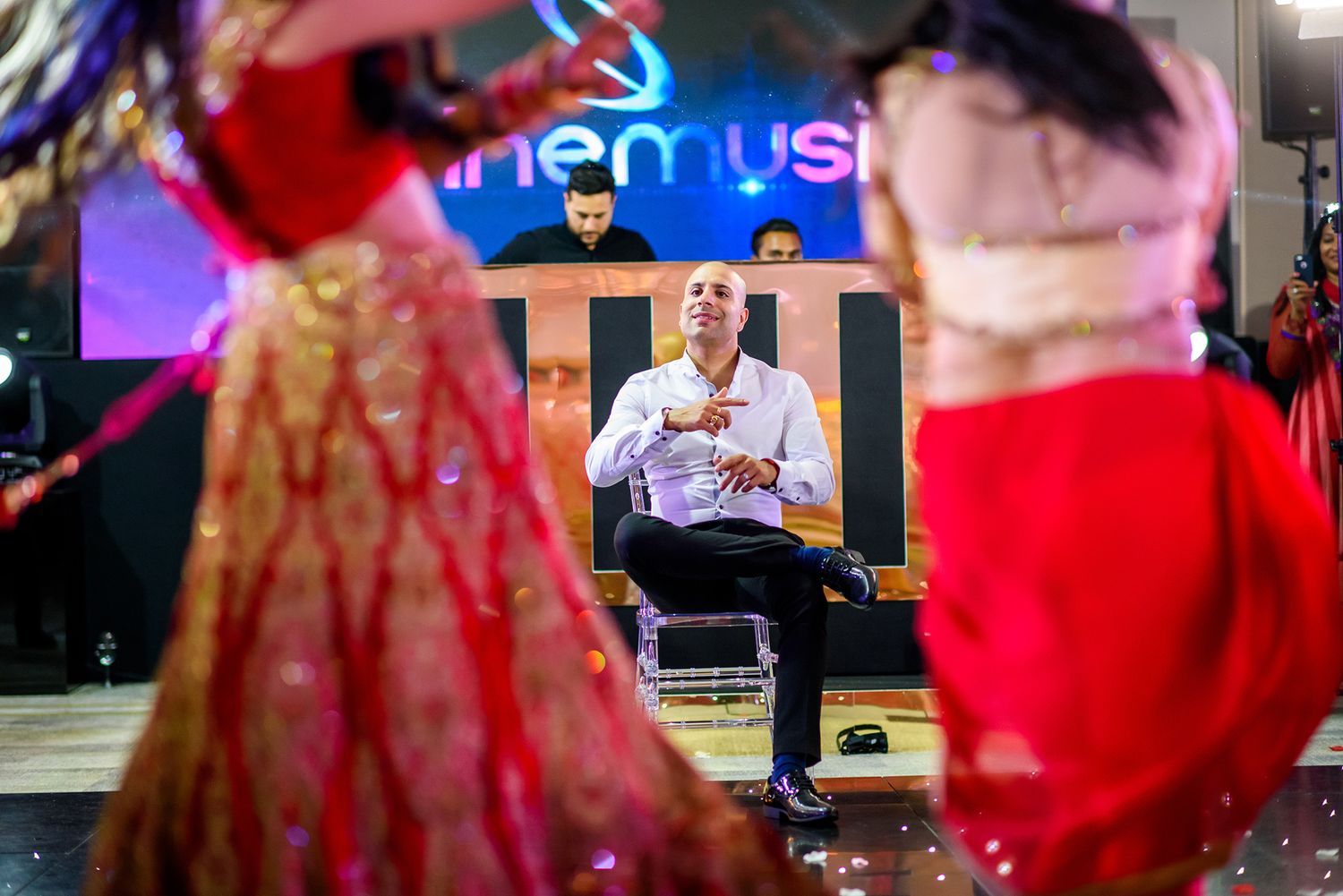 Blurred motion shots of a lively wedding reception with red and gold decor.