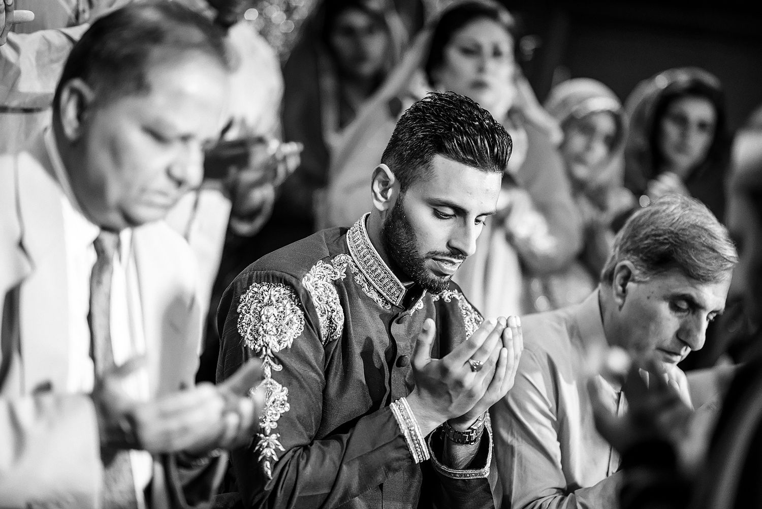 Black and white candid shots of wedding guests during an emotional moment.